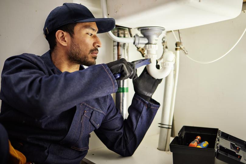 A plumber repairing a water heater